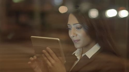 Businesswoman Using Tablet Computer at Night