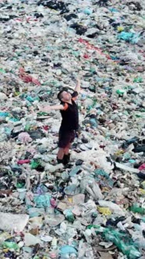 Person Stands in Massive Pile of Trash