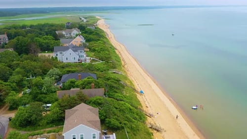 Cape Cod beach community aerial during high tide with ocean waters and boat beneath looming clouds