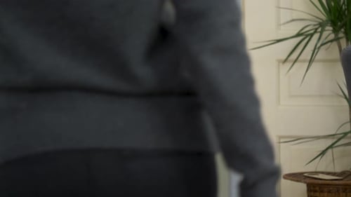 Walking woman feels sudden strong pain in anus area, clutches and massage her rear. Medium shot