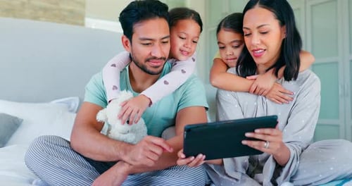 Loving Family Watching Tablet Together on Bed
