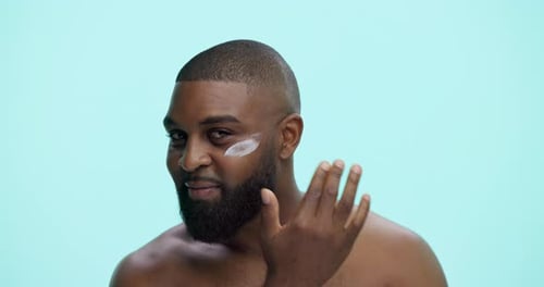 Cream, glow and face with black man in studio for skincare cosmetics, dermatology or self care
