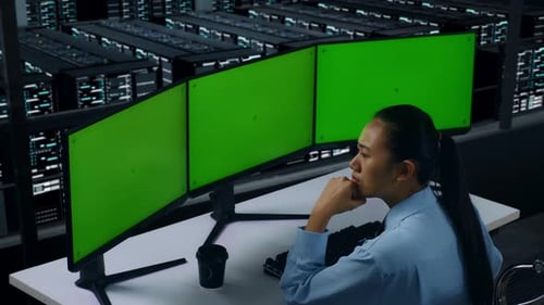 Asian Woman Thinking While Working With Mock Up Multiple Computer Monitor In Data Center