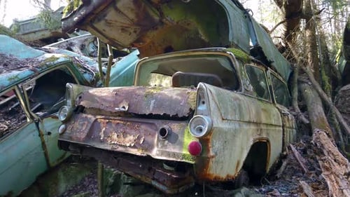 Nahaufnahme alter und rostiger Autos, die im Freien stehen gelassen wurden. Nach links schwenken