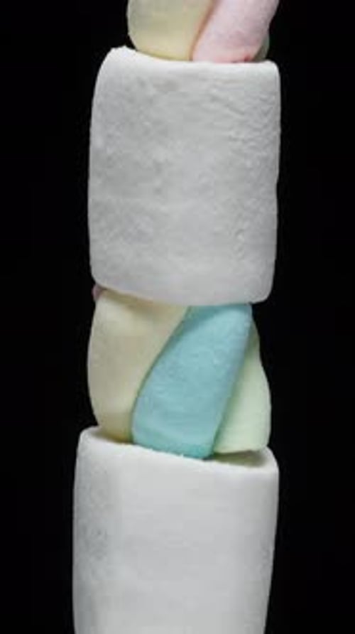 Vertical video. Marshmallows on Stick Like Sweet Skewers, White Switching to Colorful. Rotating on