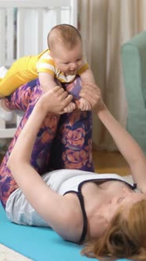 Mother Lifts Infant During At Home Workout
