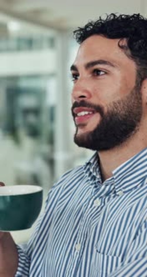 Thoughtful Man Drinking Coffee in Office Setting
