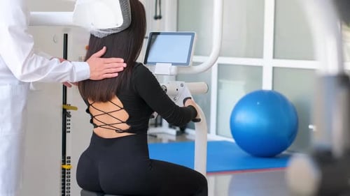 Patient Using Medical Exercise Equipment with Assistant