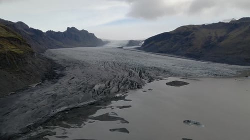 Aerial view of Skaftafell Glacier with Melted ice lagoon, Dolly sideways shot, Iceland