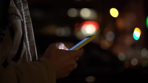 Man Hands with Phone Typing with City Lights in the Background