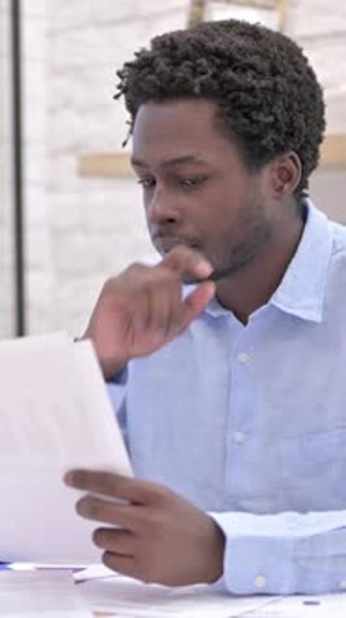 Man Reviews Documents in Bright Indoor Workplace Setting