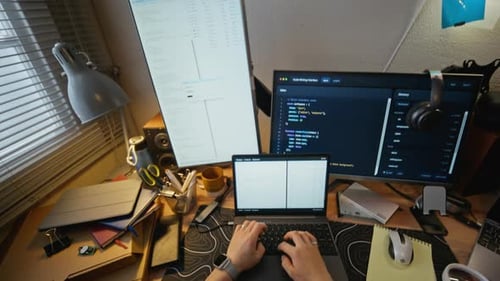Man Coding Software on Laptop Computer at Home Office