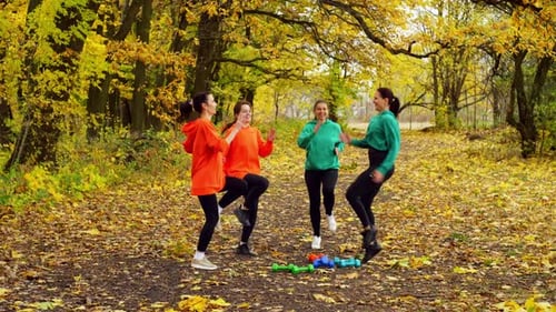 A Group of Women Run in Place with Their Knees Raised High