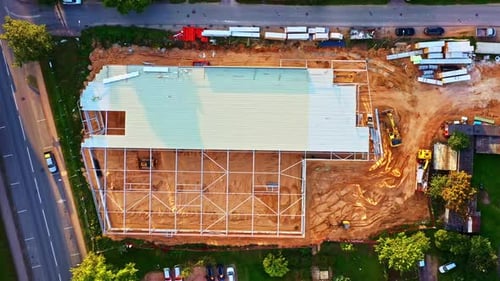 Aerial View of Large Warehouse Construction Site With Steel Frame and Roof Installed