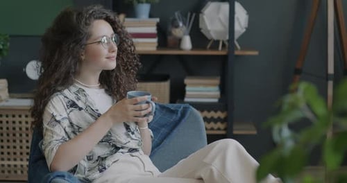 Woman Relaxing at Home Drinking Coffee or Tea