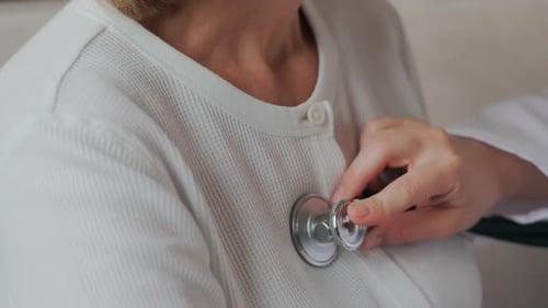 Doctor Examining Patient with Stethoscope in Clinic