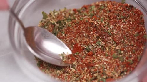 Mixing Red and Green Spices in a Bowl