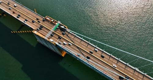 Footage above the bridge over the deep river. Suspension bridge with roads for transport traffic.