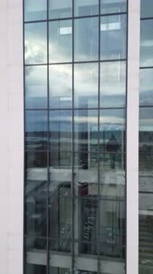 Aerial View of Moving Elevator Walls and Windows of Contemporary Business Center at Evening
