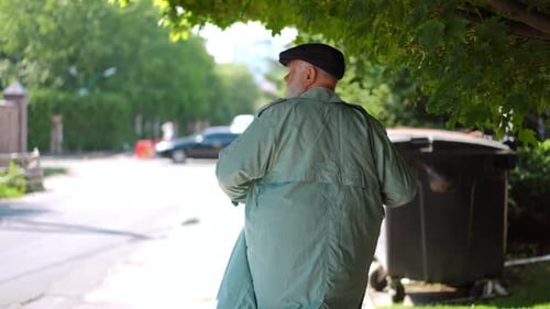 Back View Homeless Sad Senior Man Walking in Slow Motion on Sunny Urban Road Turning Looking Back