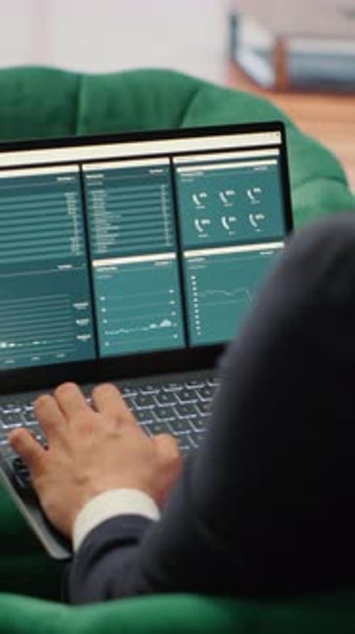 Vertical Video Determined CEO Works in Office Analyzing Infographics and Setting Business Goals