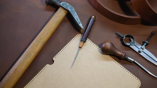 Leder-Bastelwerkzeuge und Vorlagen auf braunem Lederblatt