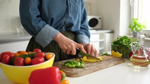 Woman Prepares Vegetables for a Fresh Salad in Kitchen