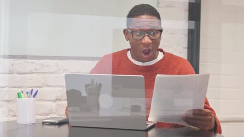 Man Celebrates Success at Laptop in Office