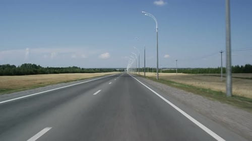 Se déplacer le long d'une route asphaltée vers l'horizon avec des arbres et du ciel