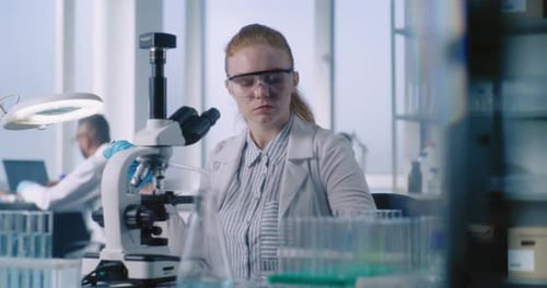 Female Scientist Working With Microscope in Lab