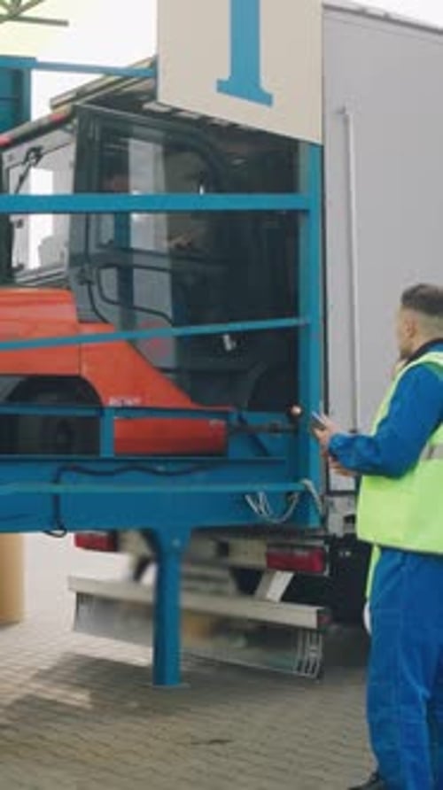 Forklift Drives Into a Truck to Unload Paper Rolls at a Paper Packaging Factory Workers at a