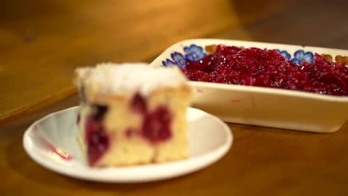 A close-up view adding the finishing touches of cherries on top of the cake.