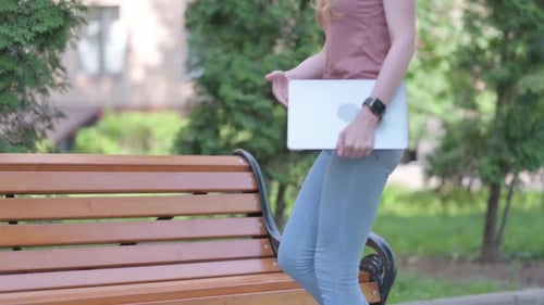 Young Woman Working on Laptop in City Park