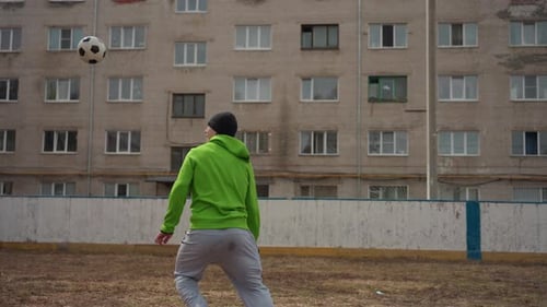 Young Man Practices Soccer Skills in Urban Setting