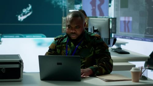 Man Working Diligently on Laptop in Modern Office