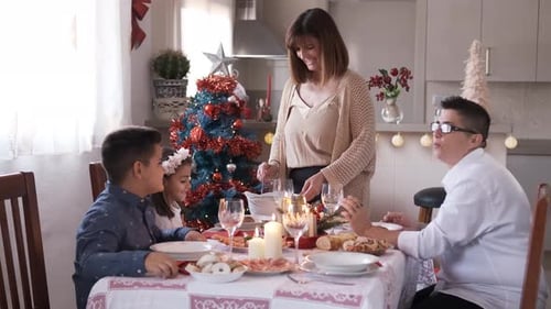 Mother Serving Food to Her Happy Family at Christmas