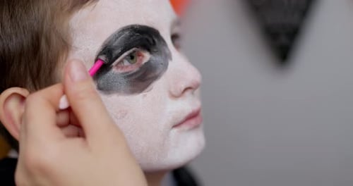 Child's Face Being Painted with Black and White Makeup for Halloween