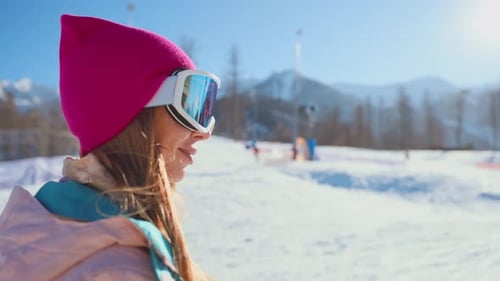 Medium Portrait of Beautiful Snowboarder Woman on Mount Slope Looking at Camera Active Pastime and