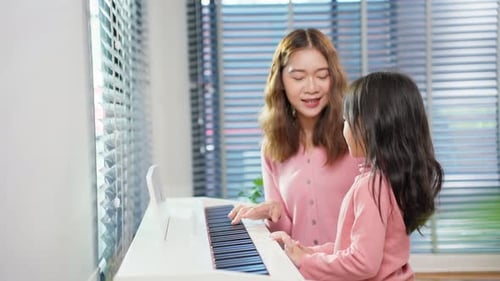Girl Learning Piano with Teacher in Sunny Home