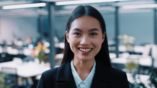 Confident Asian Businesswoman in Corporate Coworking Space Engages Colleagues