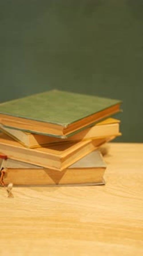 Stack of Hardcover Books on a Wooden Surface