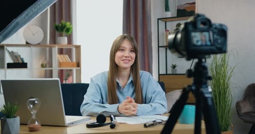 Young Adult Woman Speaks to Camera at Desk
