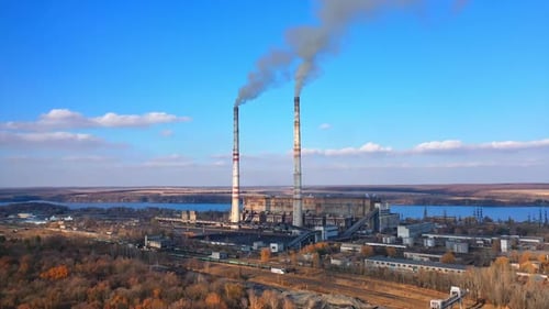 Kraftwerk und Wärmestation. Rauch und Dampf werden aus einer Industrieanlage abgegeben.