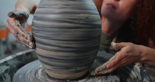 Potter Shaping Clay on a Wheel in Studio