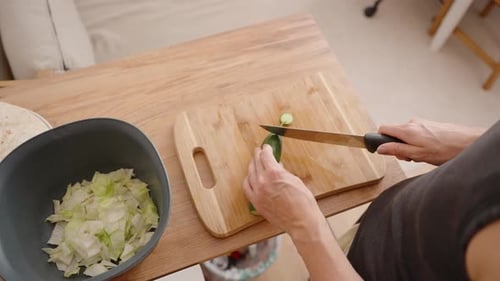 Slicing Cucumber on Cutting Board for Salad