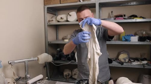 Man Manipulating Material in Medical Workplace Setting