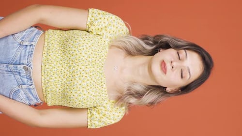 Vidéo verticale de La jeune femme qui soupire et souffle par ennui.