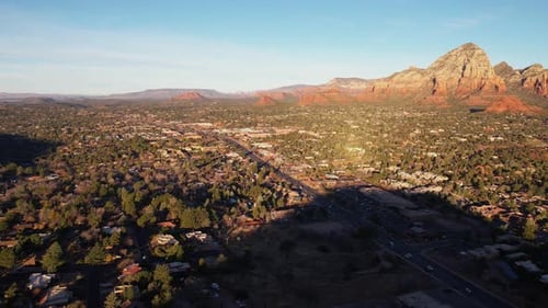Sedona, Arizona, USA, an einem sonnigen Morgen, Drohnenaufnahme von Häusern im Tal unter rotem Felsen im Sandsteinformat