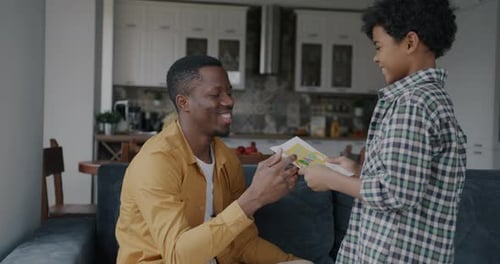 Boy Gives Father a Birthday Card and Hug