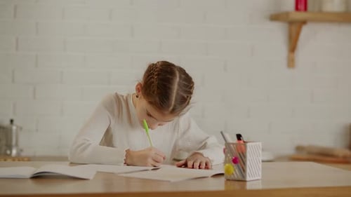 Girl Concentrating on Homework at Desk Indoors